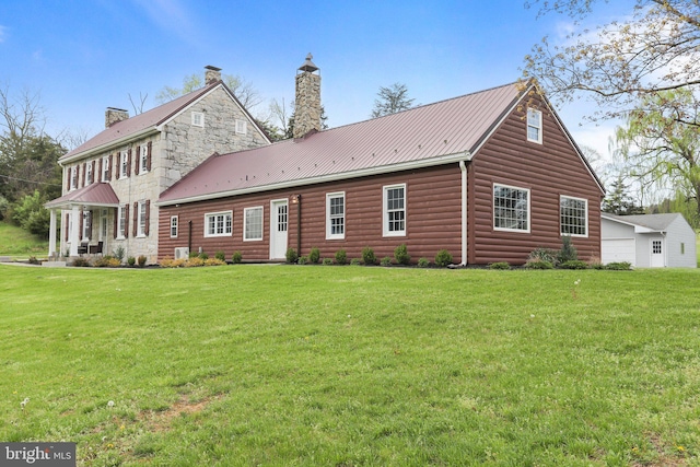 rear view of property with a garage and a lawn