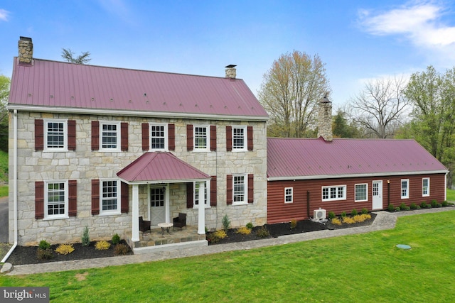 colonial inspired home with covered porch and a front lawn