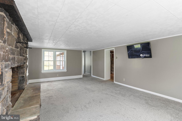 spare room featuring dark colored carpet and a fireplace