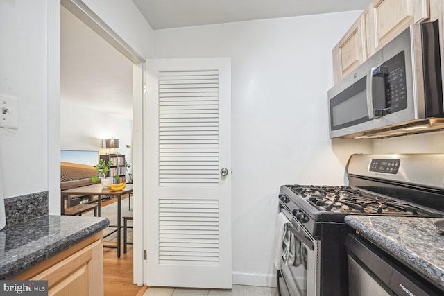 kitchen featuring appliances with stainless steel finishes, light wood-type flooring, and light brown cabinets