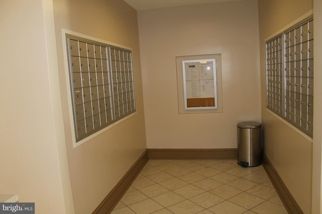 hall with a mail area and light tile floors