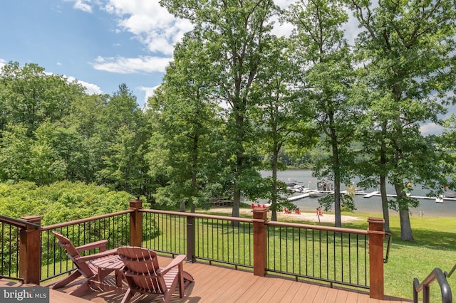 wooden terrace with a water view and a yard