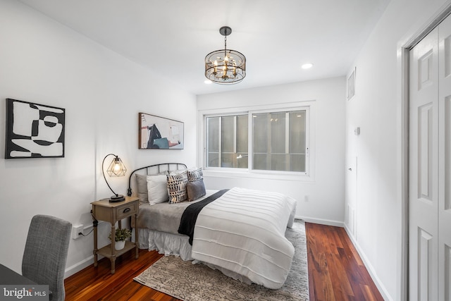 bedroom with an inviting chandelier and dark wood-type flooring