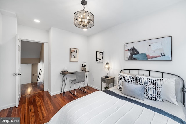 bedroom with hardwood / wood-style floors and an inviting chandelier