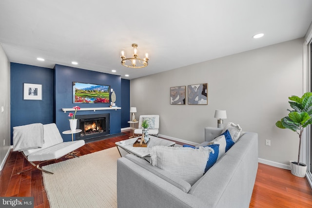 living room with dark hardwood / wood-style floors and an inviting chandelier