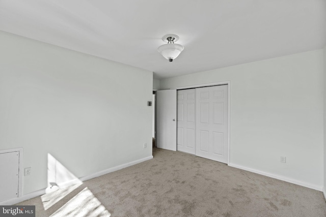 unfurnished bedroom with a closet and light carpet