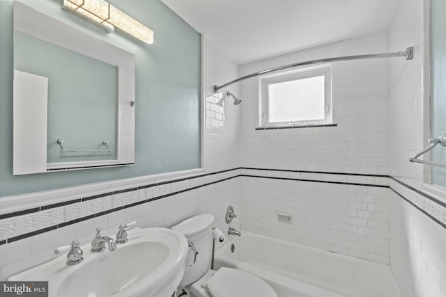 full bathroom featuring backsplash, tile walls, sink, tiled shower / bath, and toilet