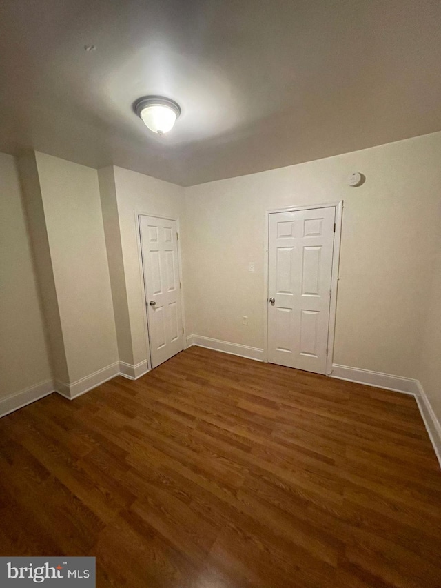 unfurnished room featuring dark wood-type flooring