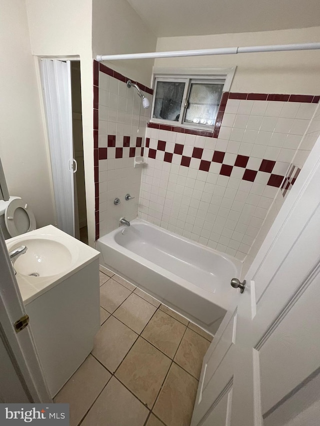 full bathroom featuring tiled shower / bath combo, vanity, tile floors, and toilet