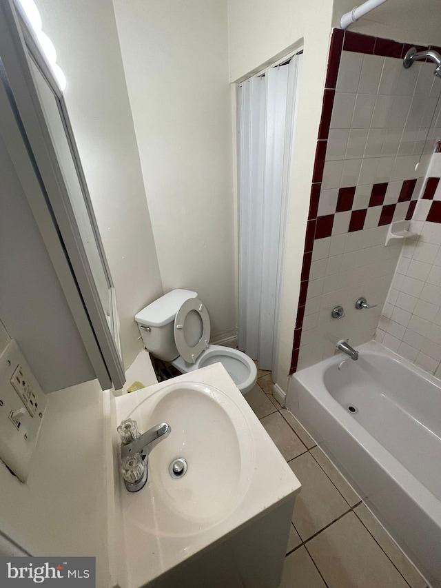 bathroom featuring tiled shower / bath combo, toilet, and tile floors