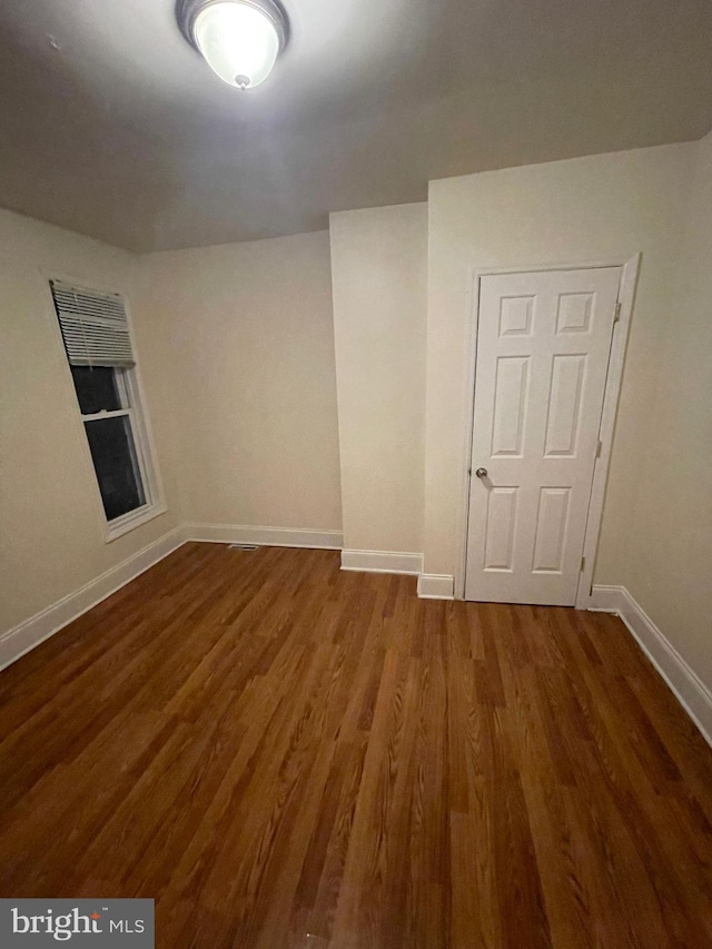 empty room with dark hardwood / wood-style floors