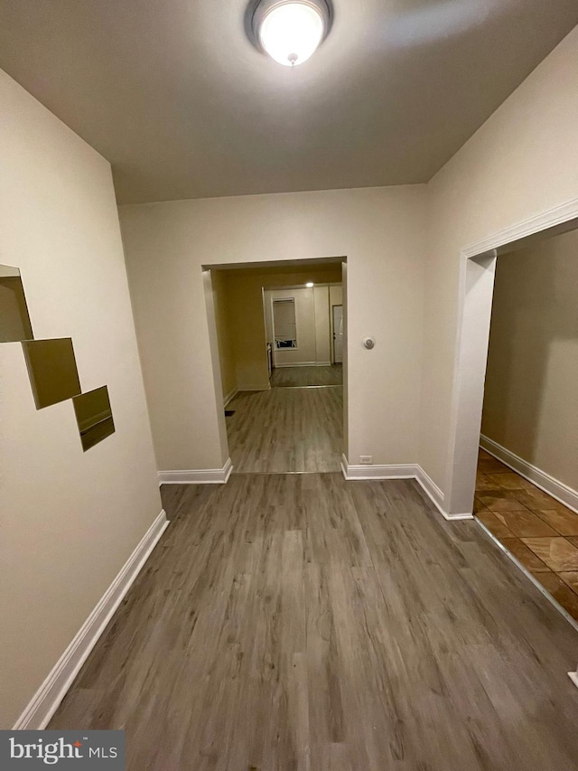 hall featuring dark tile flooring