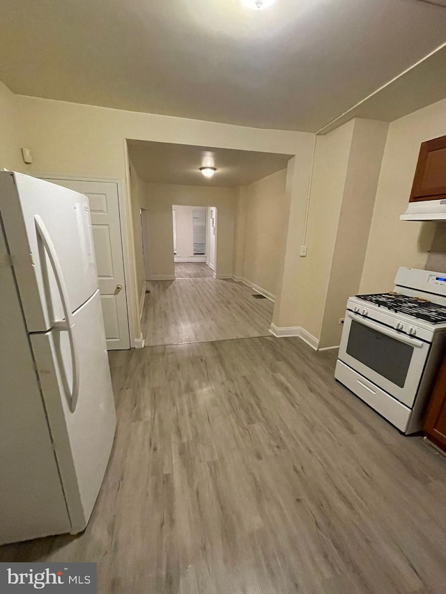 kitchen with white appliances, light hardwood / wood-style floors, and custom exhaust hood