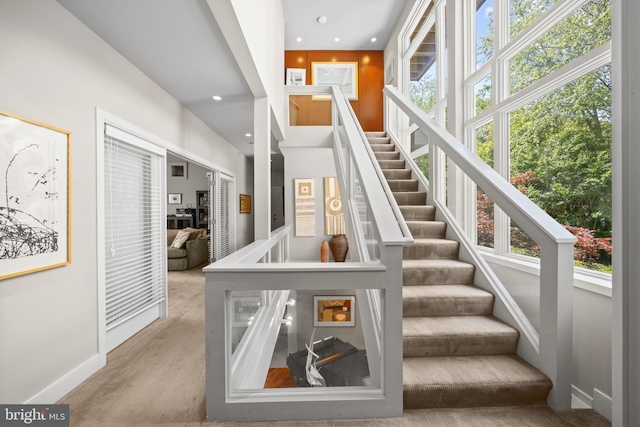 staircase with a healthy amount of sunlight and carpet floors