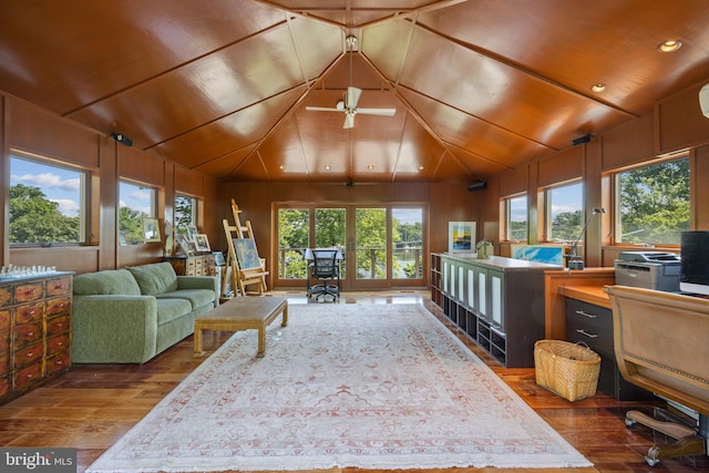 interior space featuring hardwood / wood-style floors, plenty of natural light, ceiling fan, and wood walls