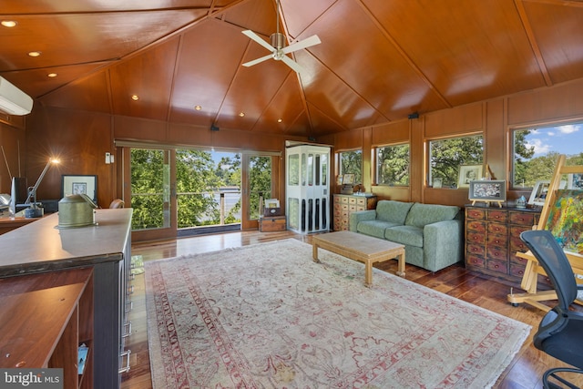 living room featuring wood-type flooring, plenty of natural light, lofted ceiling, and wood walls