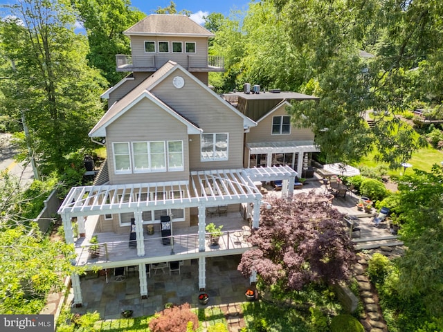 rear view of house with a pergola, a patio area, and a deck