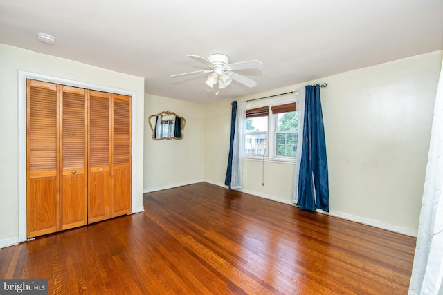 unfurnished bedroom featuring hardwood / wood-style floors, a closet, and ceiling fan