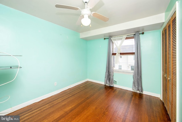 unfurnished bedroom with ceiling fan, a closet, and hardwood / wood-style flooring