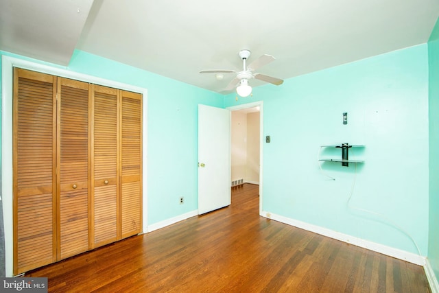 unfurnished bedroom with ceiling fan, a closet, and hardwood / wood-style flooring