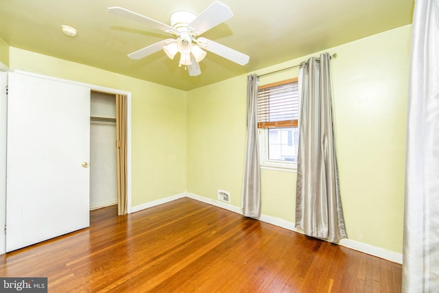 unfurnished bedroom with wood-type flooring, a closet, and ceiling fan