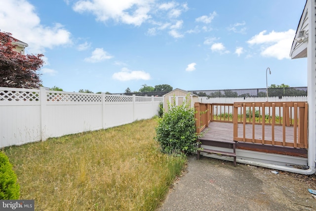 view of yard with a storage unit and a wooden deck