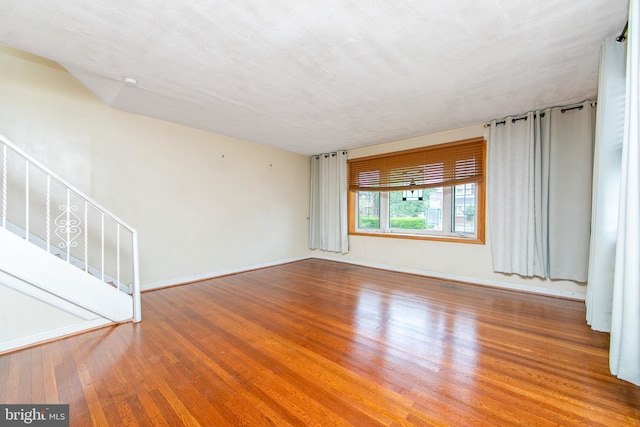 spare room featuring wood-type flooring and a textured ceiling