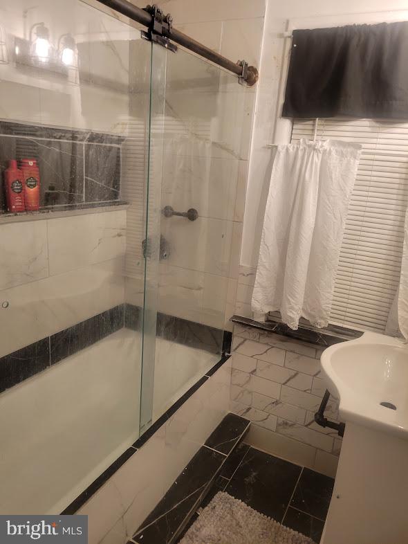 bathroom featuring enclosed tub / shower combo and tile flooring