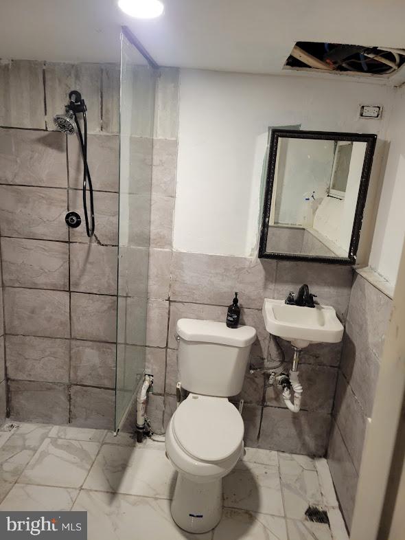 bathroom featuring tile walls, sink, tile floors, and toilet