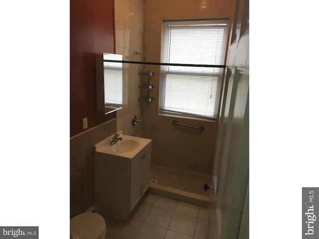 bathroom featuring toilet, vanity, and tile flooring