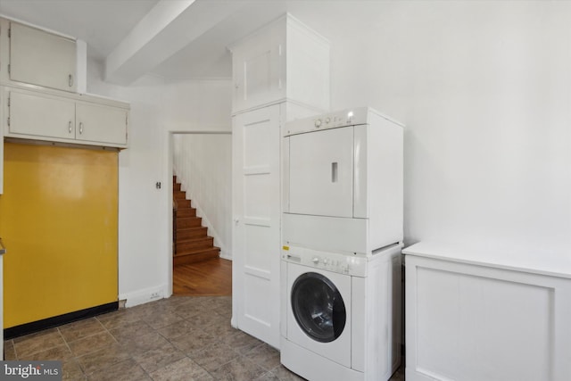 washroom featuring cabinets, tile flooring, and stacked washer and clothes dryer