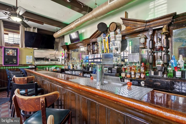 bar featuring ceiling fan, tile countertops, a wealth of natural light, and beamed ceiling