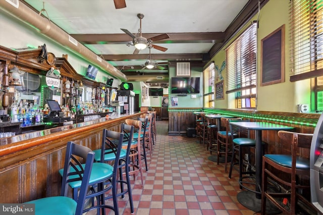 bar with ceiling fan, tile flooring, a wealth of natural light, and beamed ceiling