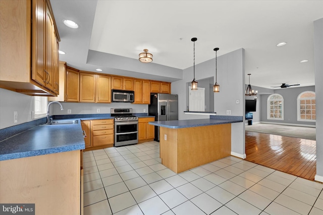 kitchen featuring stainless steel appliances, ceiling fan with notable chandelier, sink, pendant lighting, and light tile floors