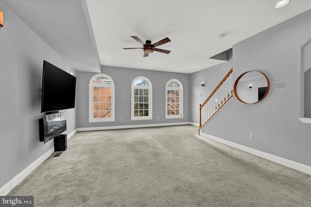 unfurnished living room featuring ceiling fan and light carpet