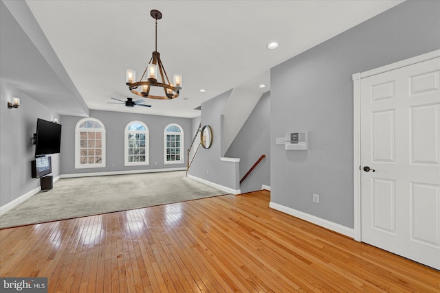 unfurnished living room with light hardwood / wood-style floors and ceiling fan with notable chandelier