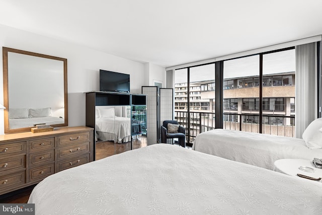 bedroom featuring dark hardwood / wood-style floors, expansive windows, and access to outside