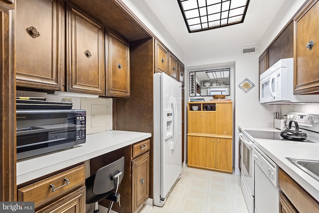 kitchen featuring white appliances and light tile floors