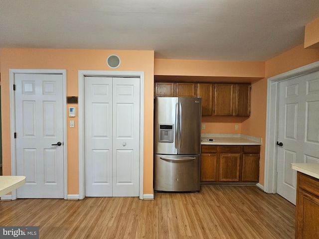 kitchen with stainless steel fridge and light hardwood / wood-style flooring