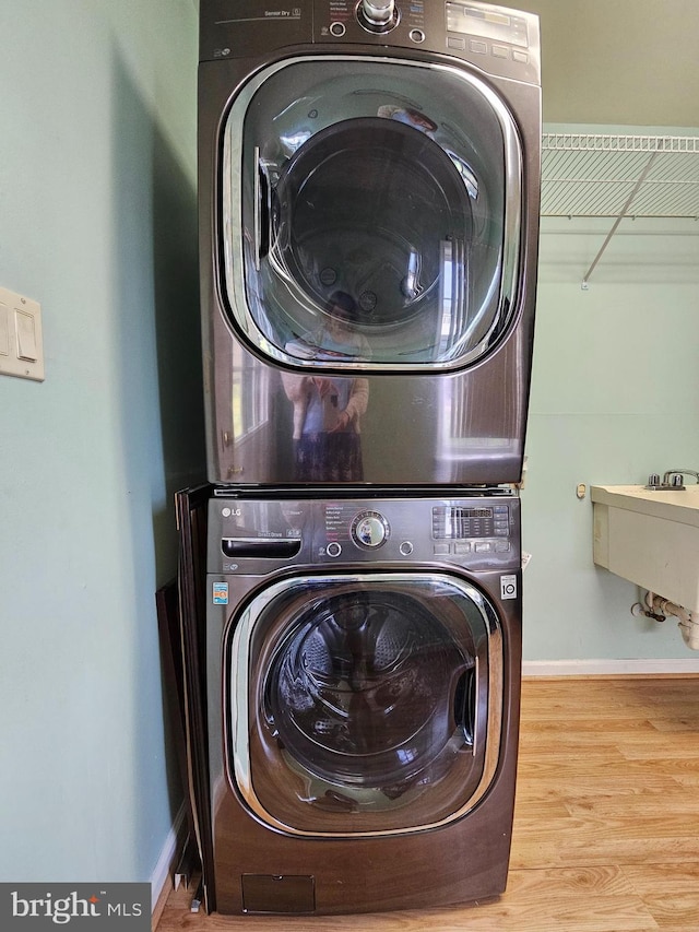 clothes washing area featuring stacked washer / dryer and hardwood / wood-style floors