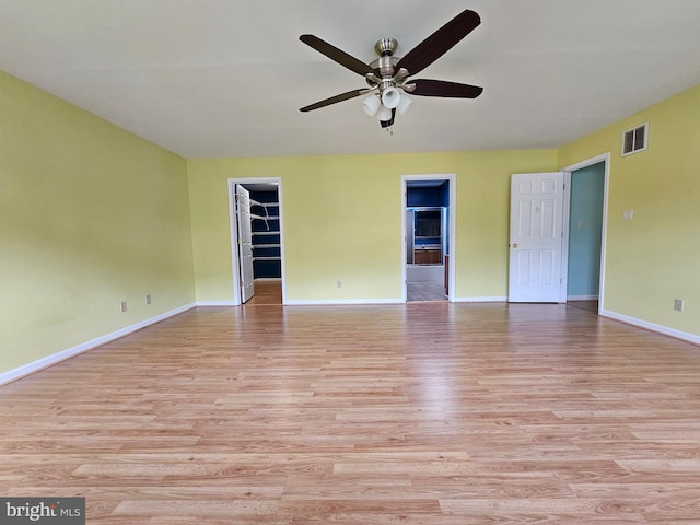 empty room with ceiling fan and light wood-type flooring