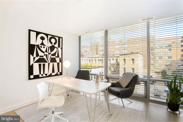 office with floor to ceiling windows and wood-type flooring