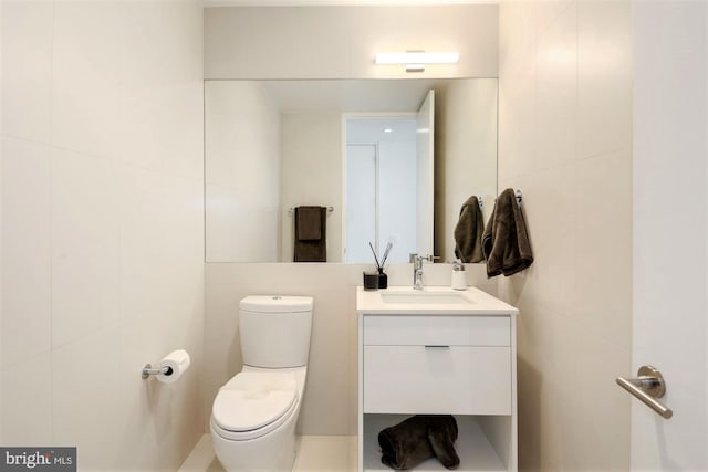 bathroom featuring tile walls, toilet, and large vanity