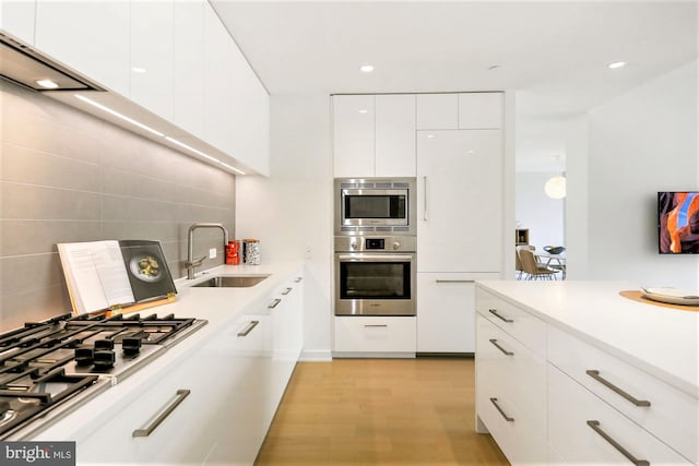 kitchen with white cabinetry, sink, tasteful backsplash, and stainless steel appliances