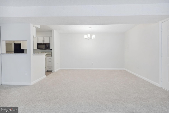 carpeted empty room with a notable chandelier