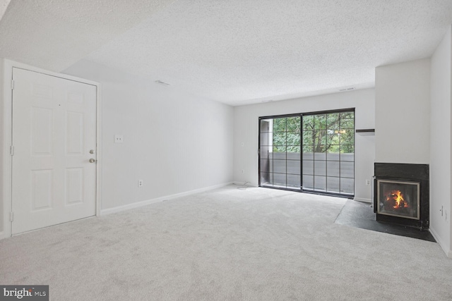 unfurnished living room featuring carpet floors and a textured ceiling