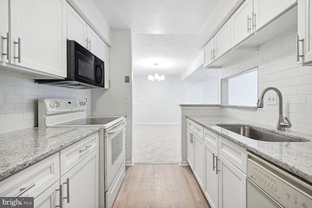 kitchen featuring white cabinetry, sink, white appliances, and light stone countertops