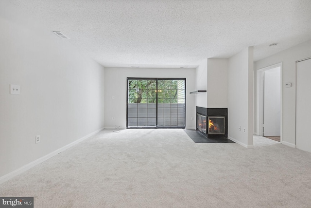 living room with a multi sided fireplace, carpet, and a textured ceiling