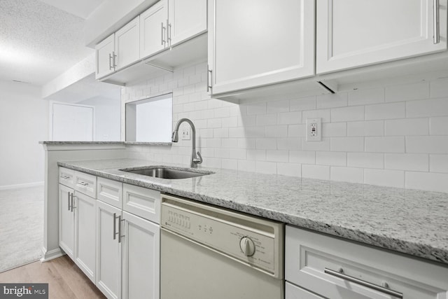 kitchen with sink, light stone counters, white cabinetry, tasteful backsplash, and white dishwasher