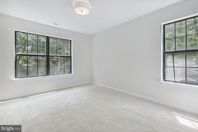 carpeted empty room featuring a textured ceiling